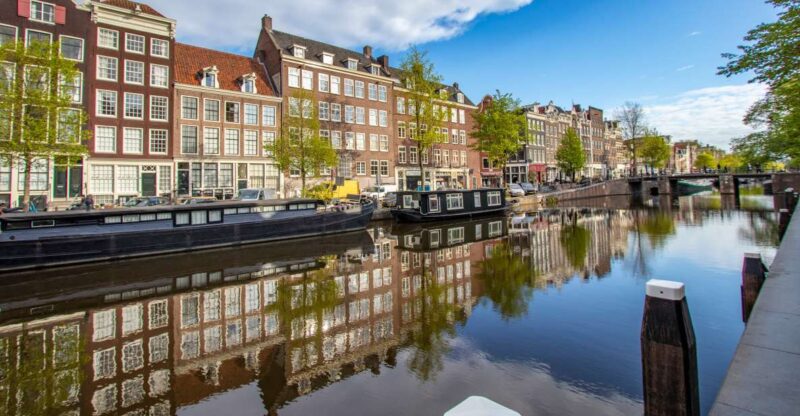 Amsterdam: Express Walk with a Local in 90 minutes - Walking Through Amsterdam’s Historic Canals and Streets