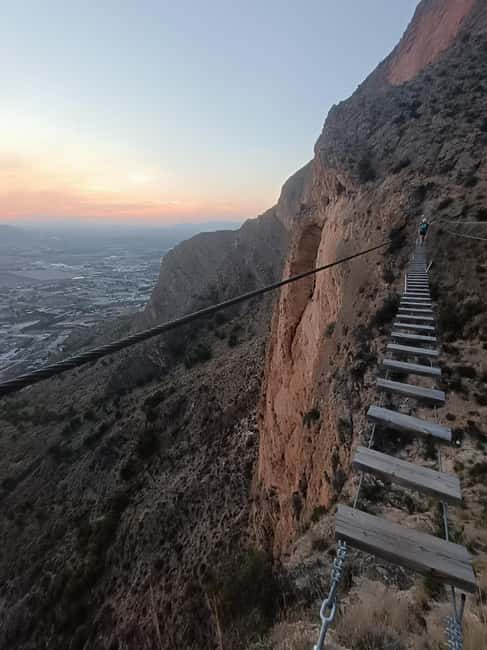 Elda: El Bolón via ferrata with zipline and abseiling - Climbing the vertical wall and crossing hanging bridges