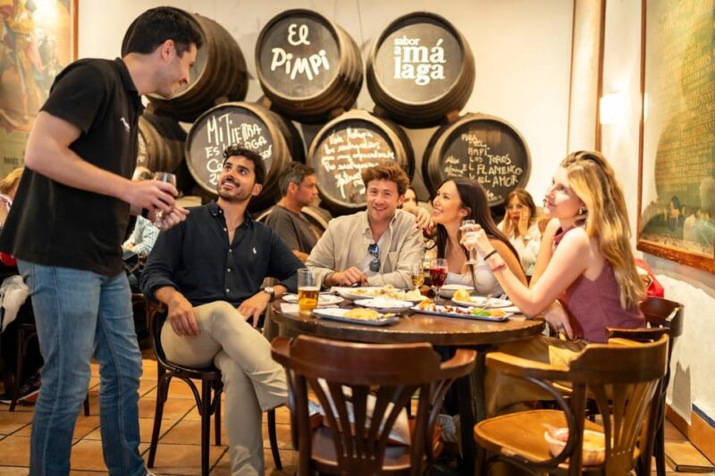 Málaga: Tapas, Wine & Rooftops Small Group Food Tour - Visiting the Old Wine Tavern and Its Lively Atmosphere